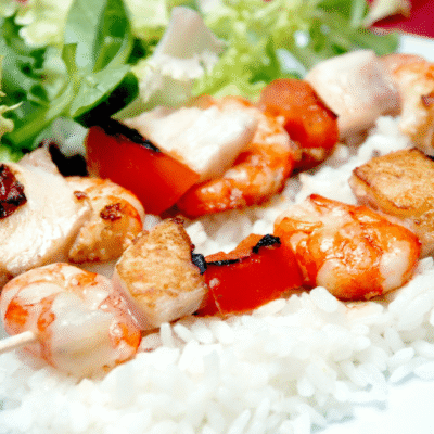Brochetas de pescado con arroz de guarnición y ensalada