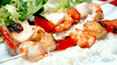 Brochetas de pescado con arroz de guarnición y ensalada