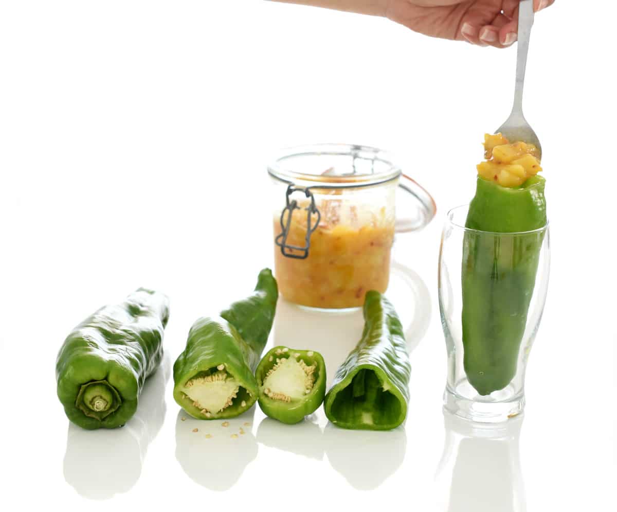 Vacía los pimientos de semillas y colócalos dentro de un vaso para rellenarlos fácilmente Vacía los pimientos de semillas y colócalos dentro de un vaso para rellenarlos fácilmente